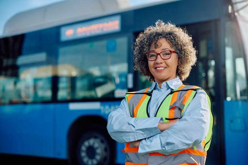 Woman bus driver standing near a bus