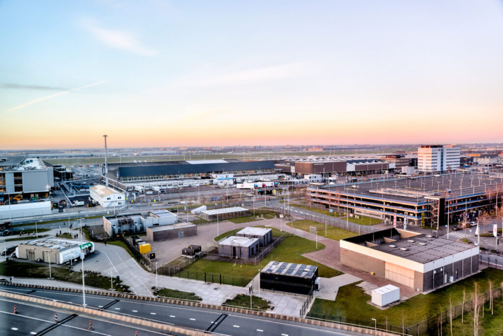 Modern industrial complex at sunset, featuring sleek buildings and bustling logistics center.