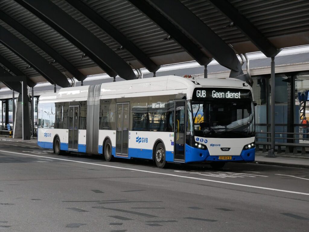 Modern articulated bus at Amsterdam terminal, showcasing sleek design and GVB branding.