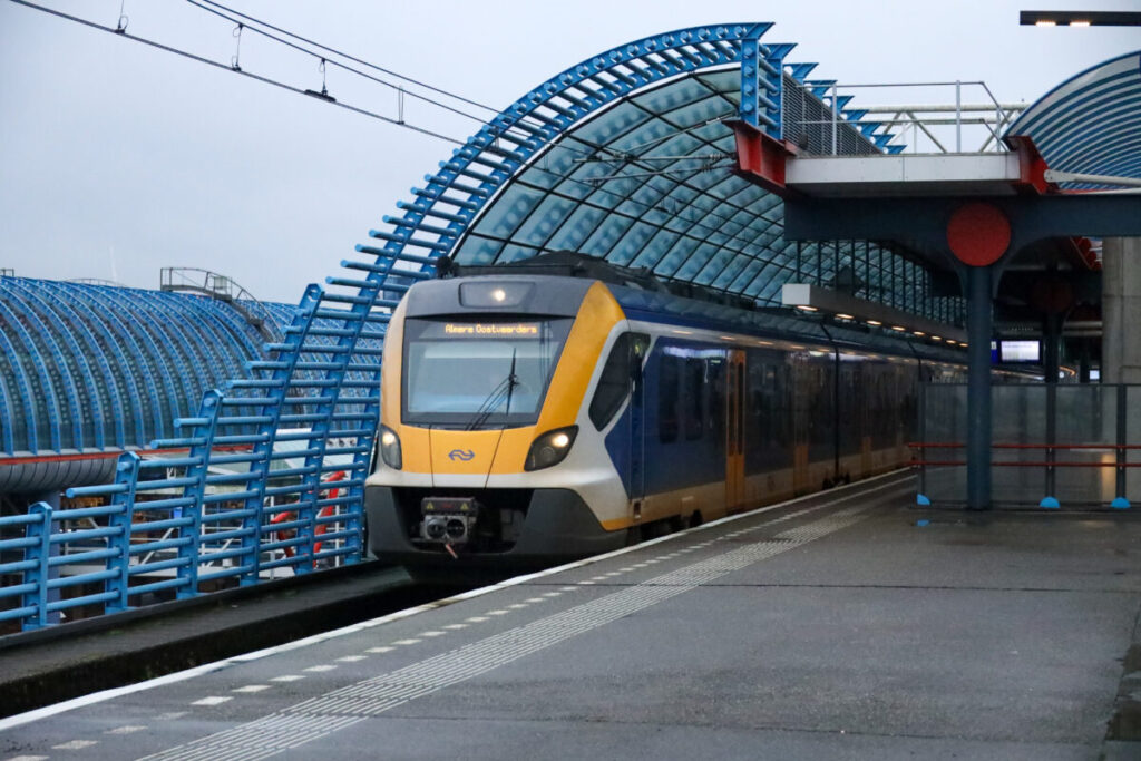 Sleek electric train at Amsterdam Sloterdijk station platform, showcasing modern European commuter transit.