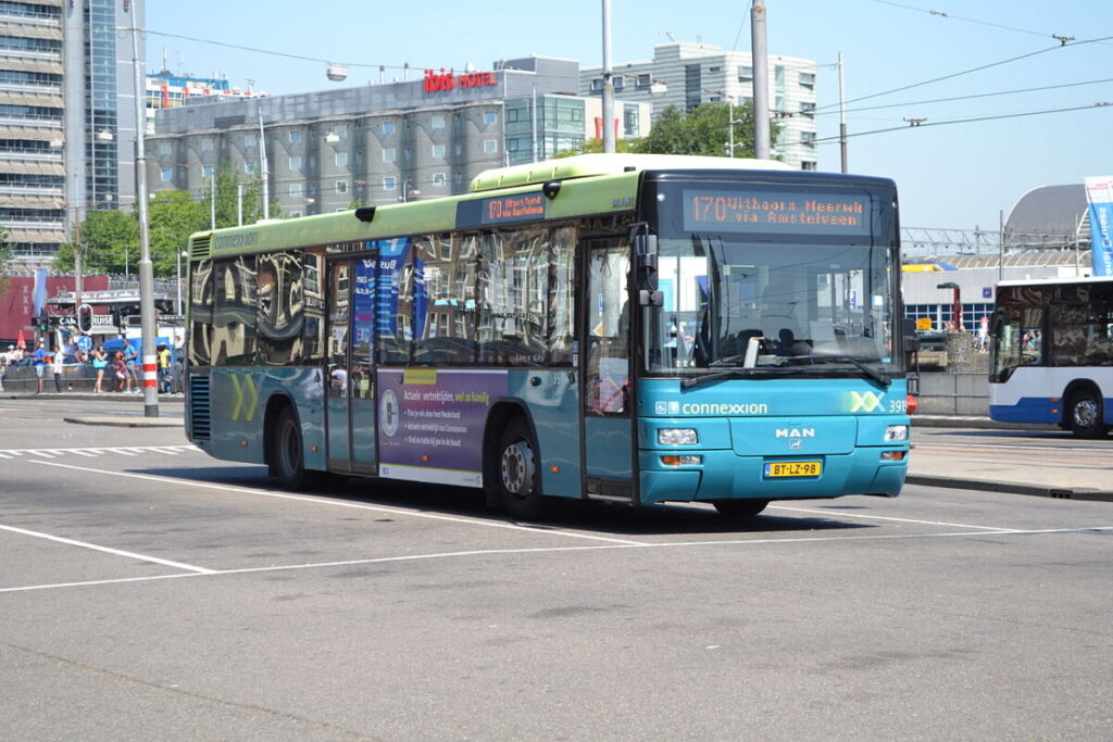 Connexxion bus on route 170 in a vibrant urban setting with modern architecture.