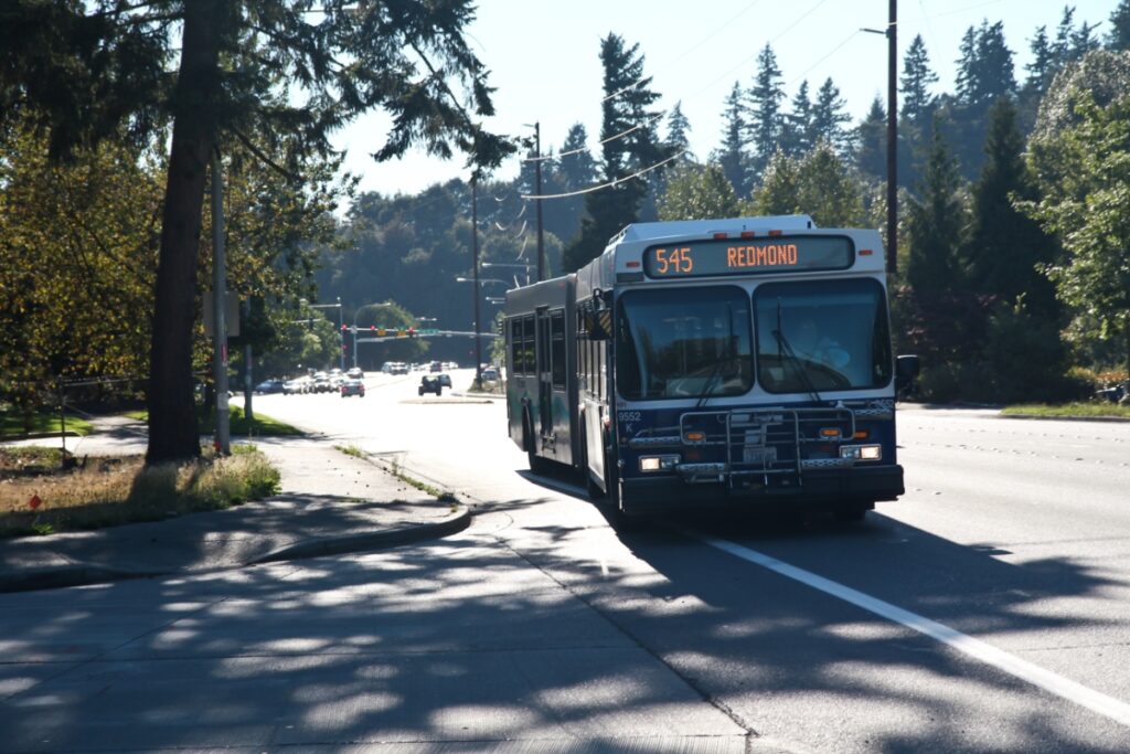 City bus 545 to Redmond on a sunny urban road with greenery.