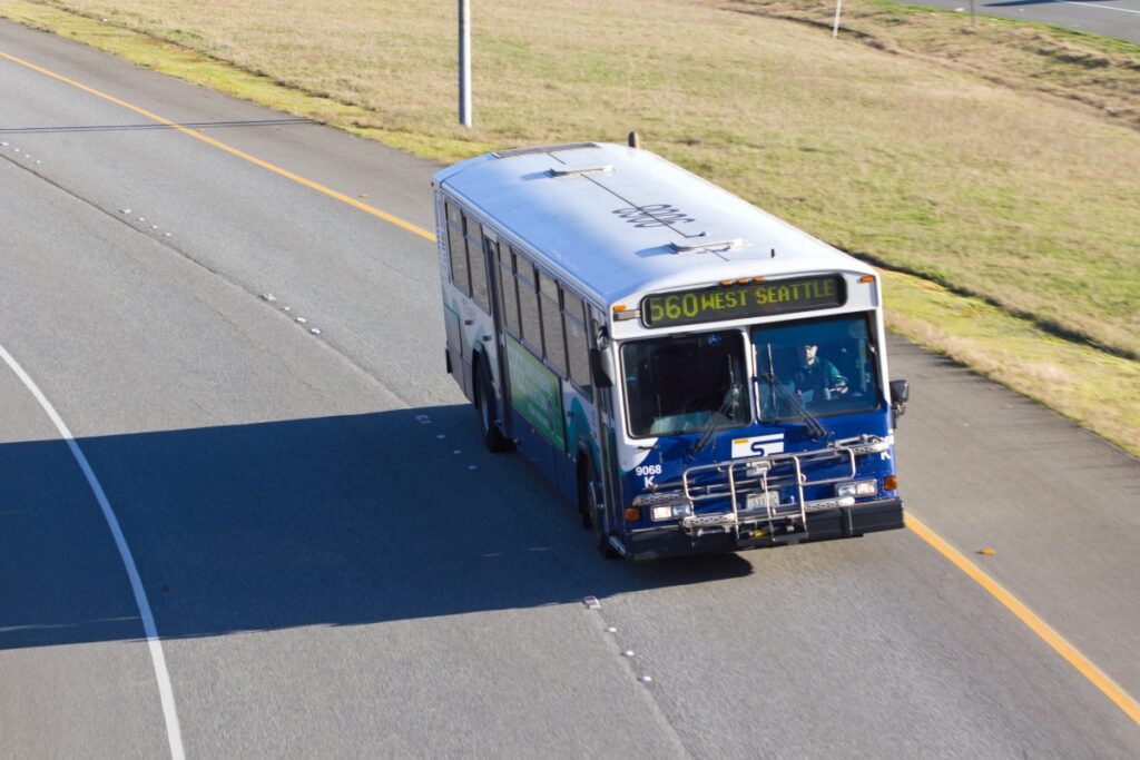 Modern transit bus on highway, route 560 to West Seattle, serene urban travel scene.