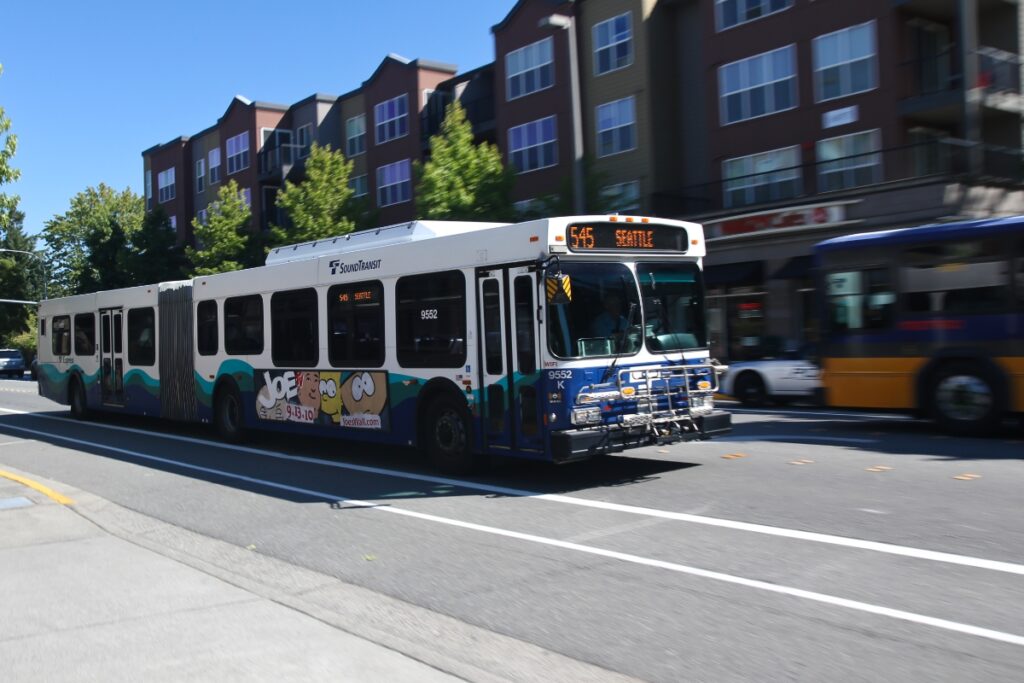 Sound Transit bus on Route 545 heading to Seattle in a vibrant urban city scene.